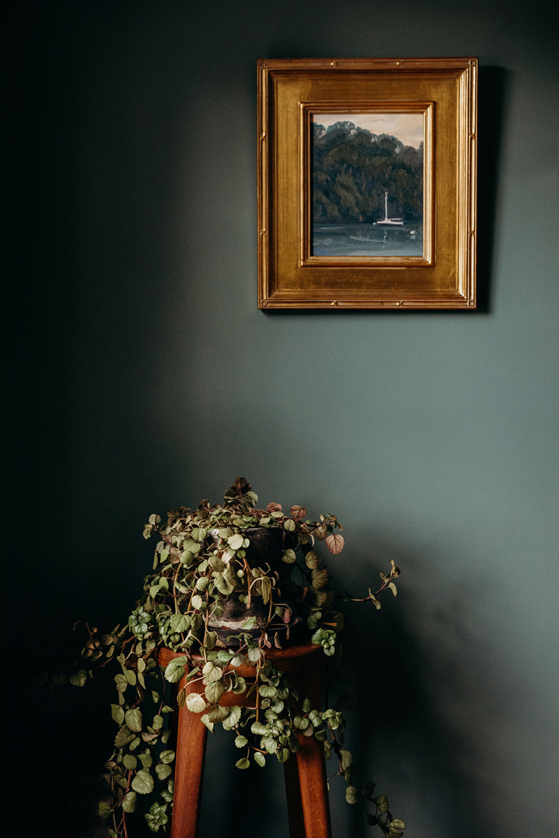 Sailboat painting in green room with plant